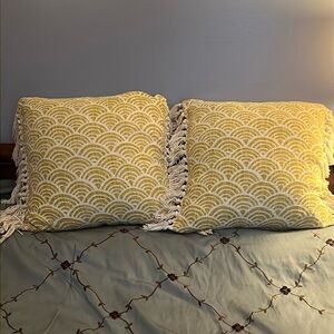 Throw Pillows with mustard yellow & white geometric pattern & fringed edges.